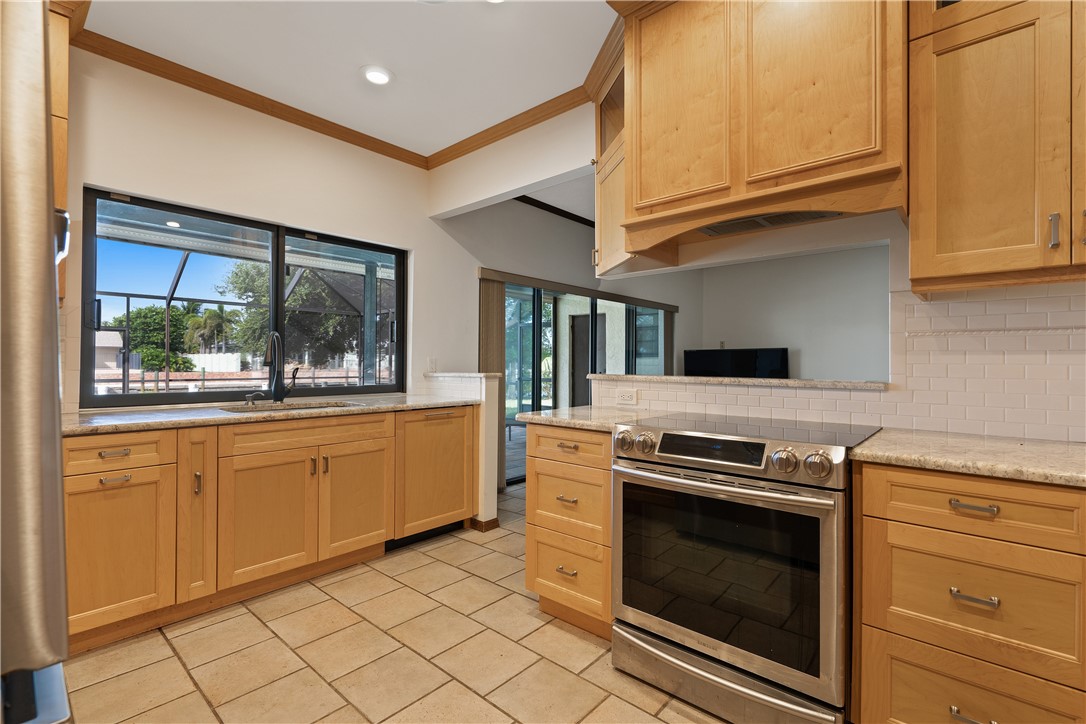 1713 Sunset Isles Road Fort Pierce, FL 34949 - Photo 11 of 36 a kitchen with granite countertop white cabinets stainless steel appliances and sink