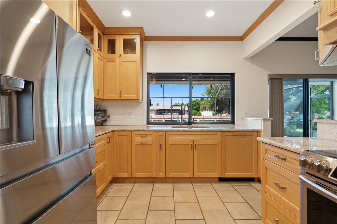 1713 Sunset Isles Road Fort Pierce, FL 34949 - Photo 12 of 36 a kitchen with stainless steel appliances granite countertop a refrigerator and a stove
