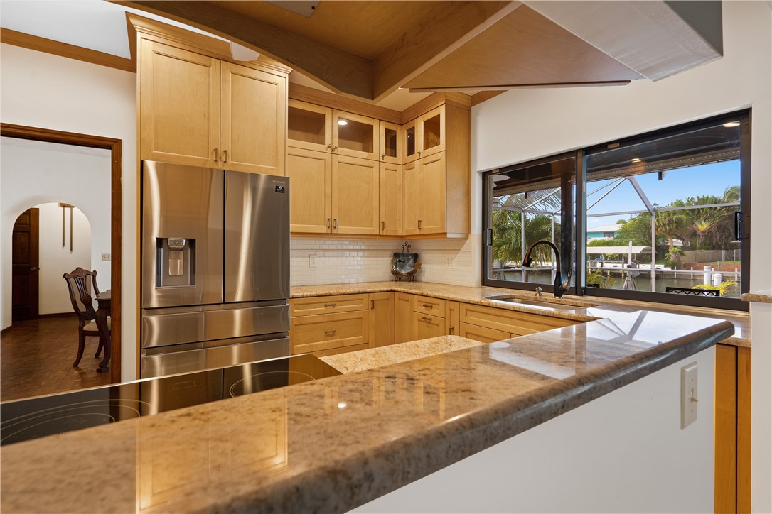 1713 Sunset Isles Road Fort Pierce, FL 34949 - Photo 14 of 36 a kitchen with stainless steel appliances granite countertop a refrigerator a sink and a stove
