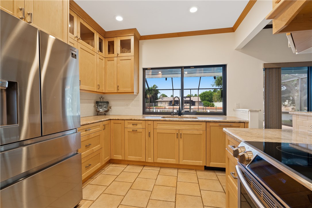 1713 Sunset Isles Road Fort Pierce, FL 34949 - Photo 15 of 36 a kitchen with stainless steel appliances granite countertop a refrigerator and a sink