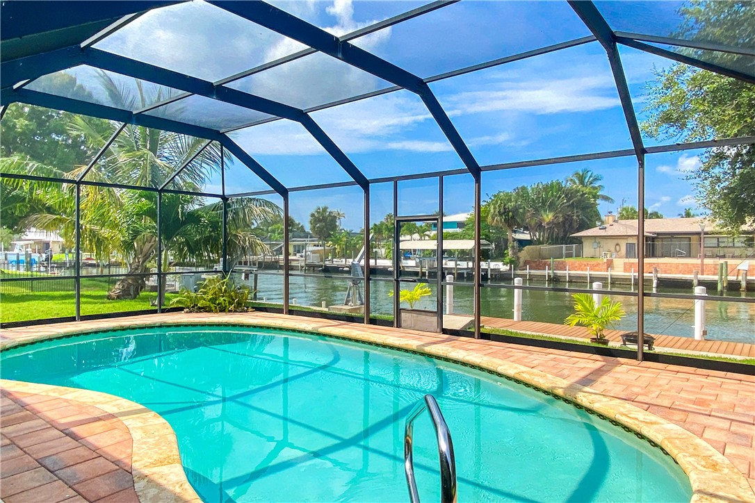 1713 Sunset Isles Road Fort Pierce, FL 34949 - Photo 2 of 36 a swimming pool with lawn chairs