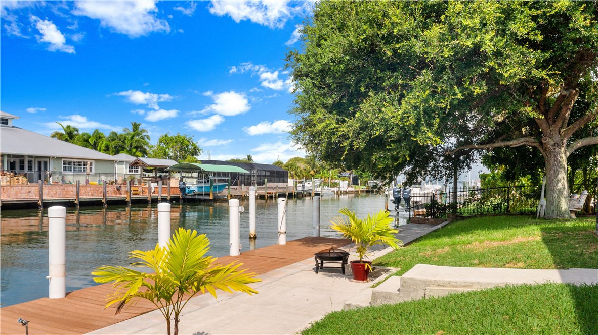 1713 Sunset Isles Road Fort Pierce, FL 34949 - Photo 29 of 36 a view of a lake with couches and wooden fence