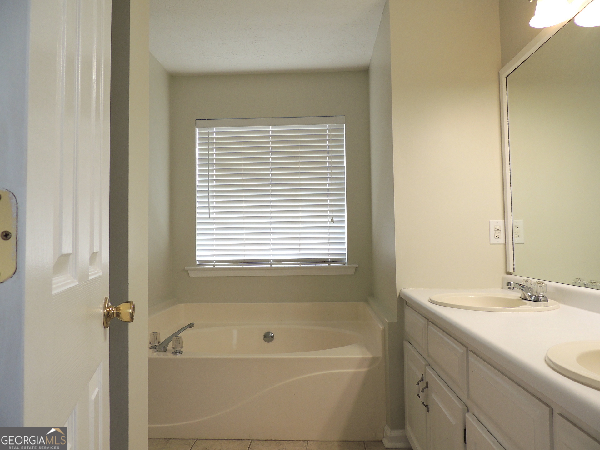 10 Brandon Drive Covington, GA 30016 - Photo 11 of 13 a bathroom with a tub a sink and a window