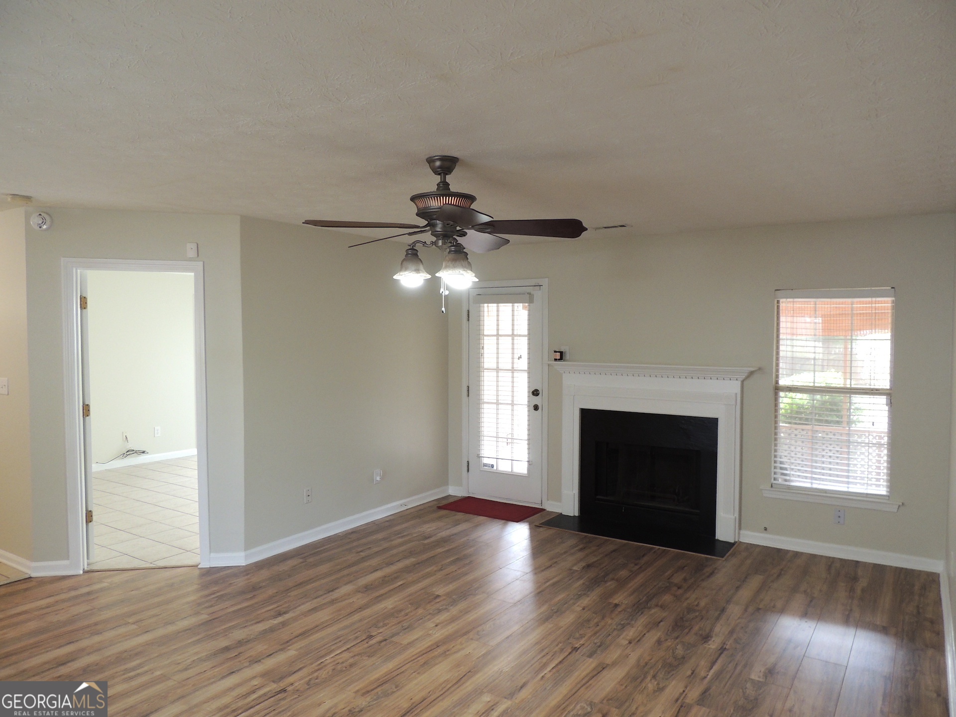 10 Brandon Drive Covington, GA 30016 - Photo 4 of 13 a view of an empty room with wooden floor fireplace and a window