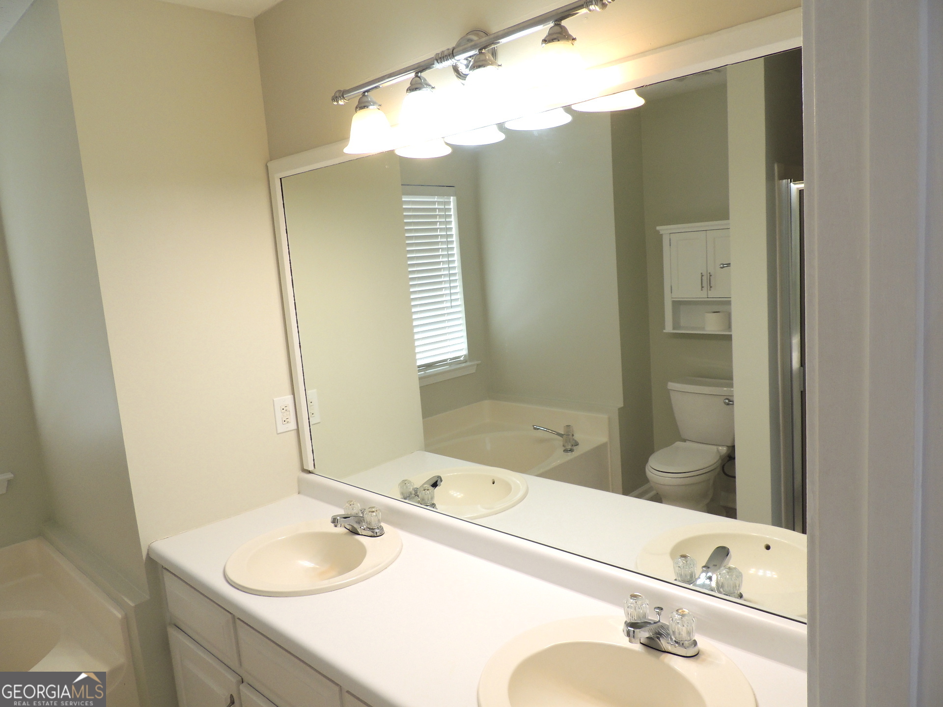 10 Brandon Drive Covington, GA 30016 - Photo 10 of 13 a bathroom with a tub sink and mirror