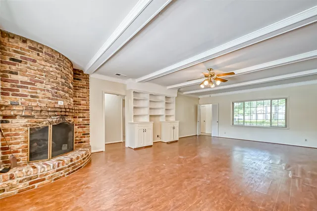 an empty room with windows and fireplace