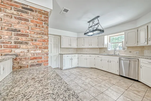 a kitchen with granite countertop a sink and cabinets