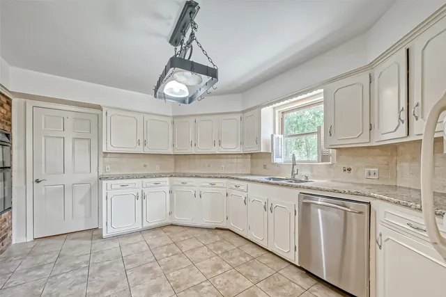 a kitchen with granite countertop white cabinets white appliances with a sink and dishwasher