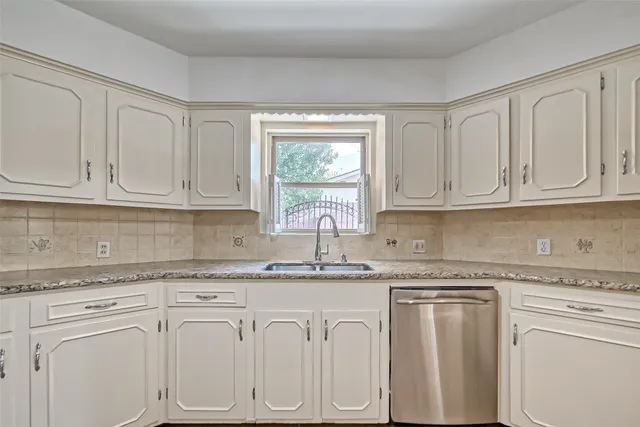 a kitchen with granite countertop white cabinets and white appliances