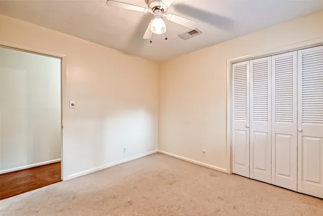 an empty room with fan and windows