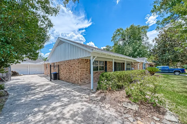 a view of a house with a yard and large tree