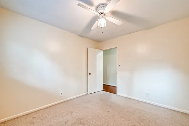 an empty room with a ceiling fan and a window