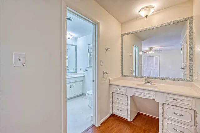 a spacious bathroom with a granite countertop sink and a mirror