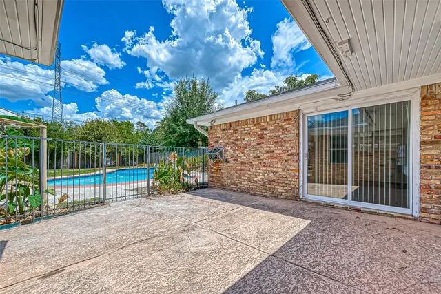 a view of a backyard with brick wall and potted plants