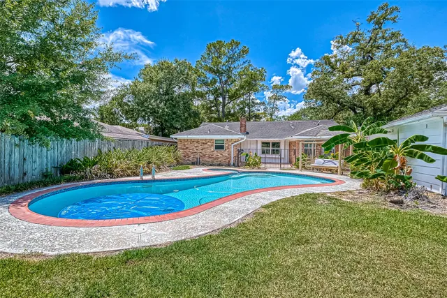 a view of a house with swimming pool and yard