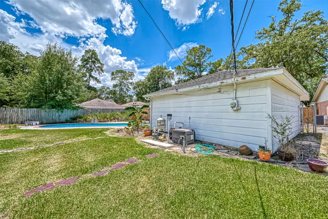 a backyard of a house with table and chairs plants and large tree