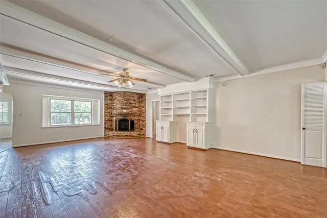 an empty room with windows fireplace and windows