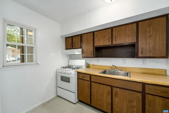 a utility room with stainless steel appliances white cabinets and a sink