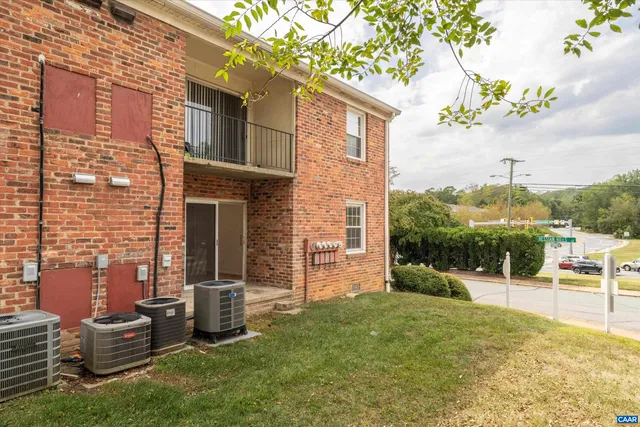 a view of a brick house with a yard and table and chairs