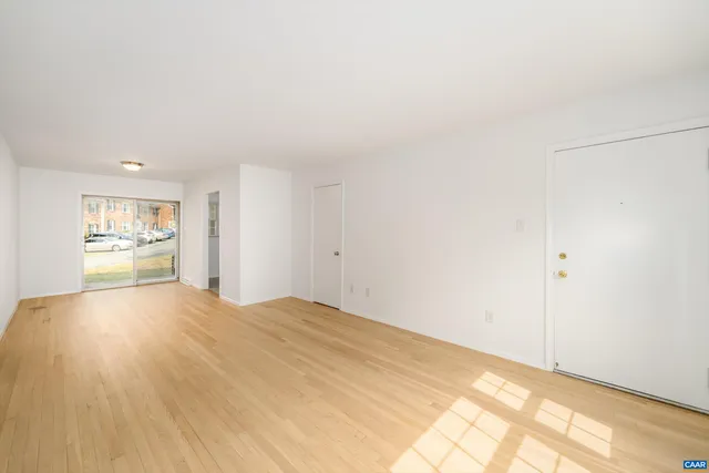 a view of empty room with wooden floor