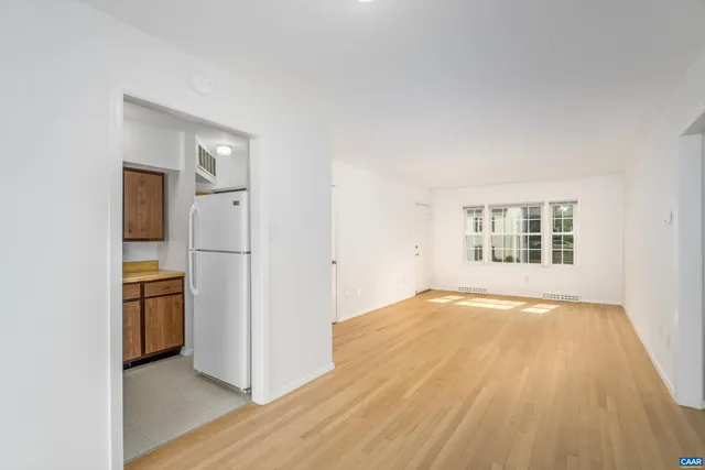 an empty room with a kitchen and a window