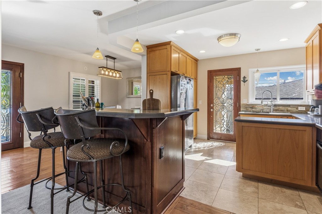 22709 Gaycrest Avenue Torrance, CA 90505 - Photo 8 of 22 a dining hall with stainless steel appliances kitchen island granite countertop a table and chairs