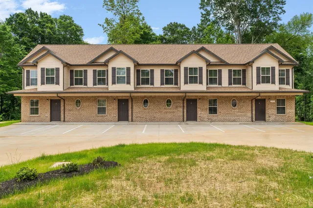 a front view of a house with a garden and yard