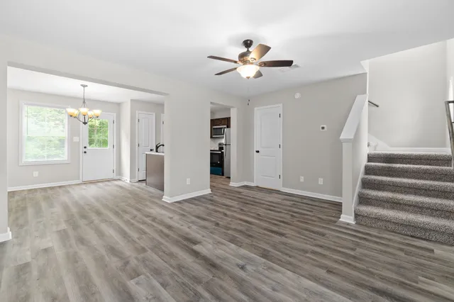 a view of an empty room with wooden floor and window