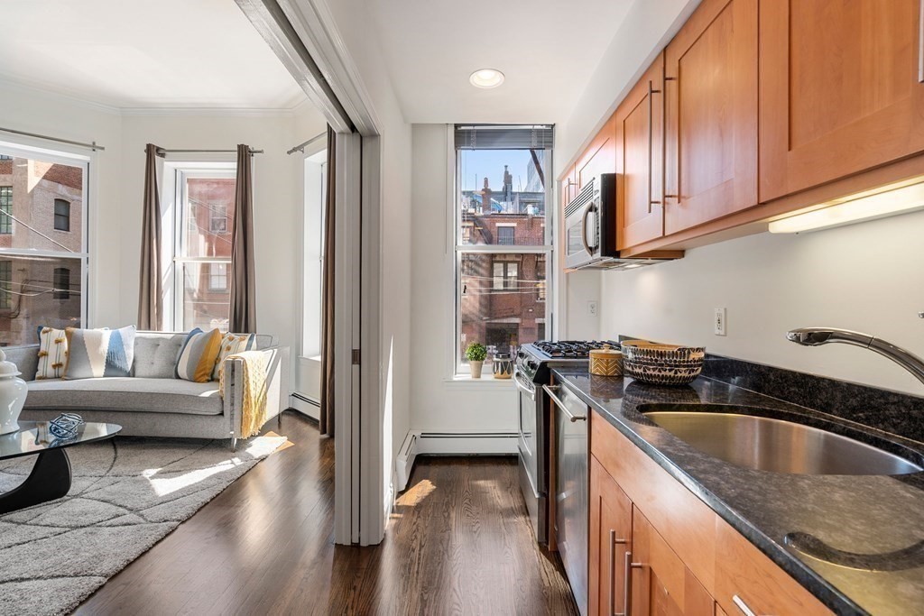 352 Commonwealth Avenue, Unit 2 Boston, MA 02115 - Photo 5 of 25 a kitchen with granite countertop a stove a sink and a refrigerator