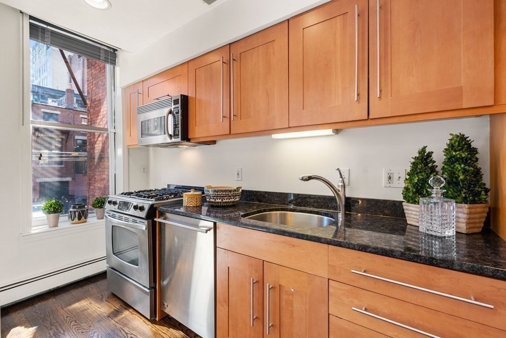 352 Commonwealth Avenue, Unit 2 Boston, MA 02115 - Photo 6 of 25 a kitchen with stainless steel appliances granite countertop a sink a stove and a microwave