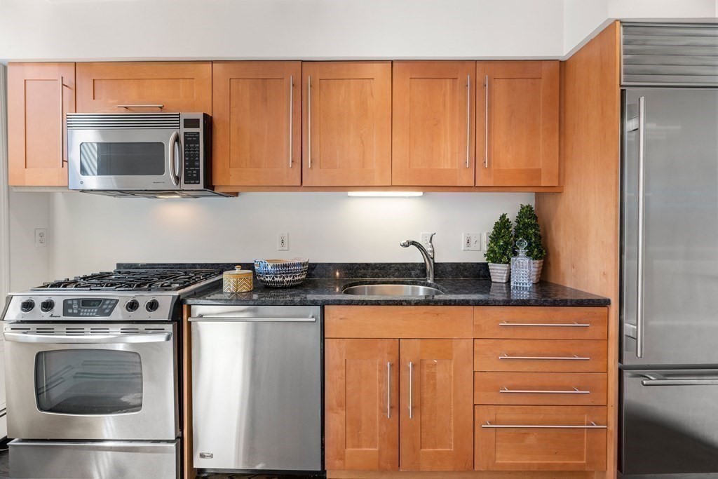 352 Commonwealth Avenue, Unit 2 Boston, MA 02115 - Photo 7 of 25 a kitchen with granite countertop stainless steel appliances a stove a microwave and cabinets