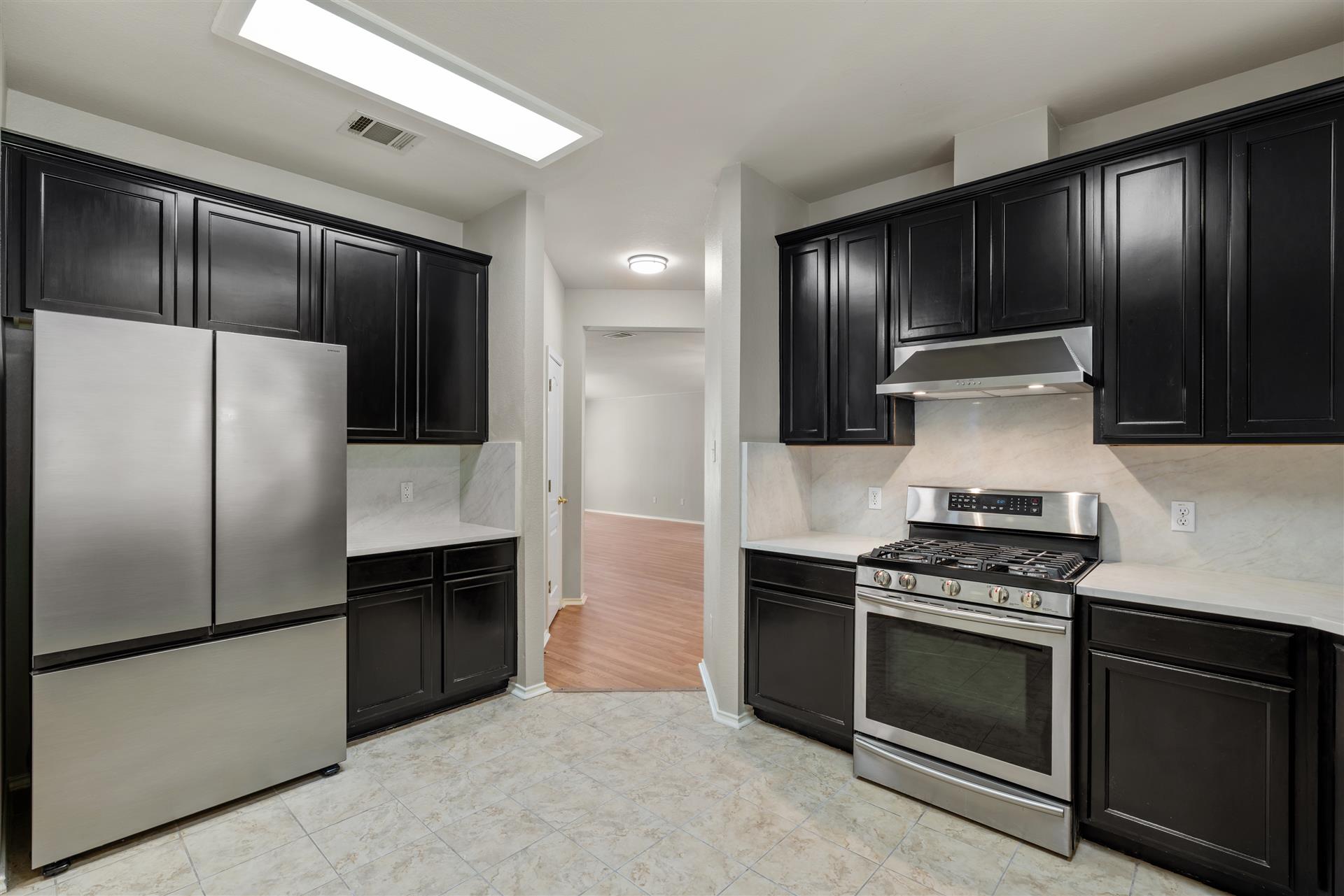 4725 Tello Path Austin, TX 78749 - Photo 13 of 34 Modern kitchen featuring sleek black cabinetry and stainless steel appliances.