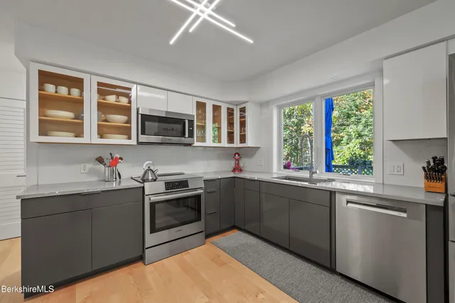 a kitchen with stainless steel appliances granite countertop a sink and stove top oven