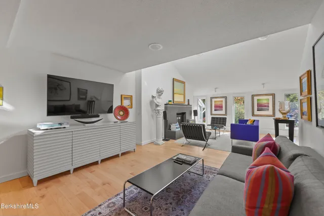 a living room with furniture kitchen view and a flat screen tv