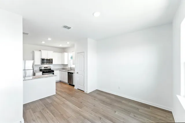 a kitchen with a refrigerator and a stove top oven