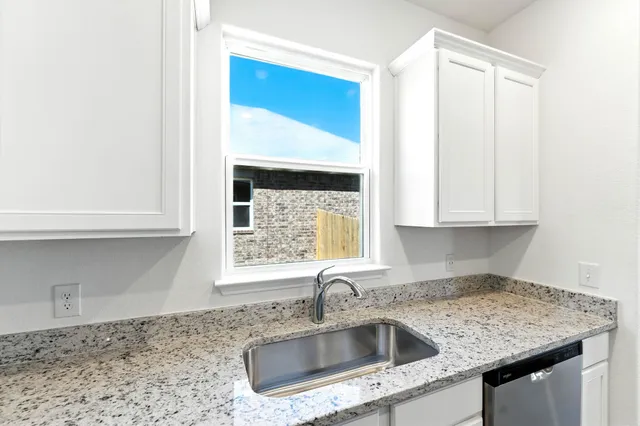 a kitchen with granite countertop a sink and a stove