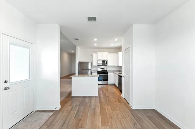 a kitchen with a sink and wooden floor