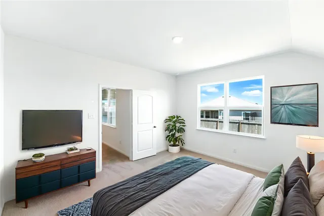 a bedroom with furniture and a flat screen tv