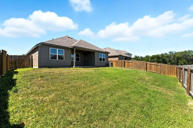a large white house with a big yard and large trees