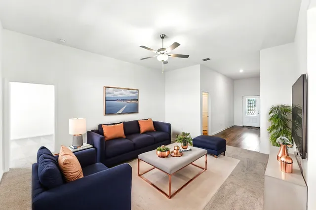 a living room with furniture a chandelier and a rug