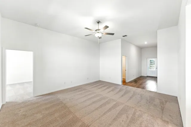 a view of a big room with closet and a ceiling fan