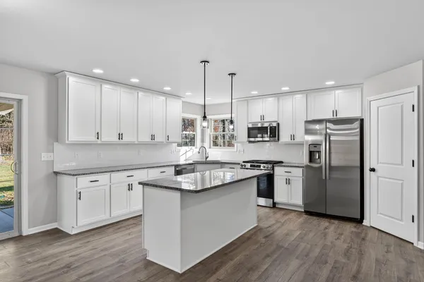 a kitchen with stainless steel appliances granite countertop a sink stove and refrigerator