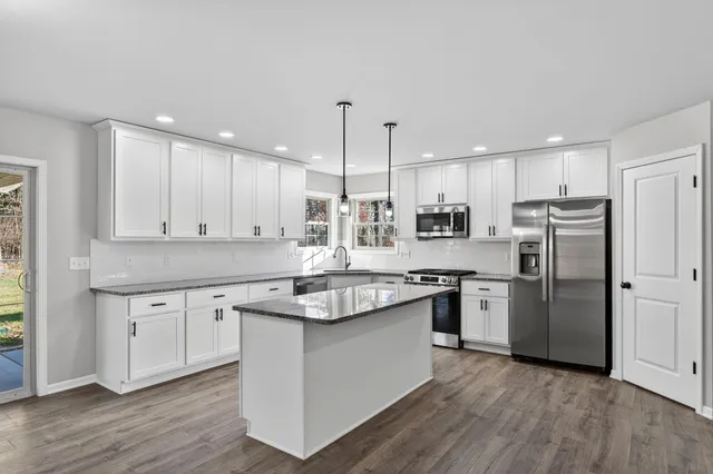 a kitchen with stainless steel appliances granite countertop a sink stove and refrigerator