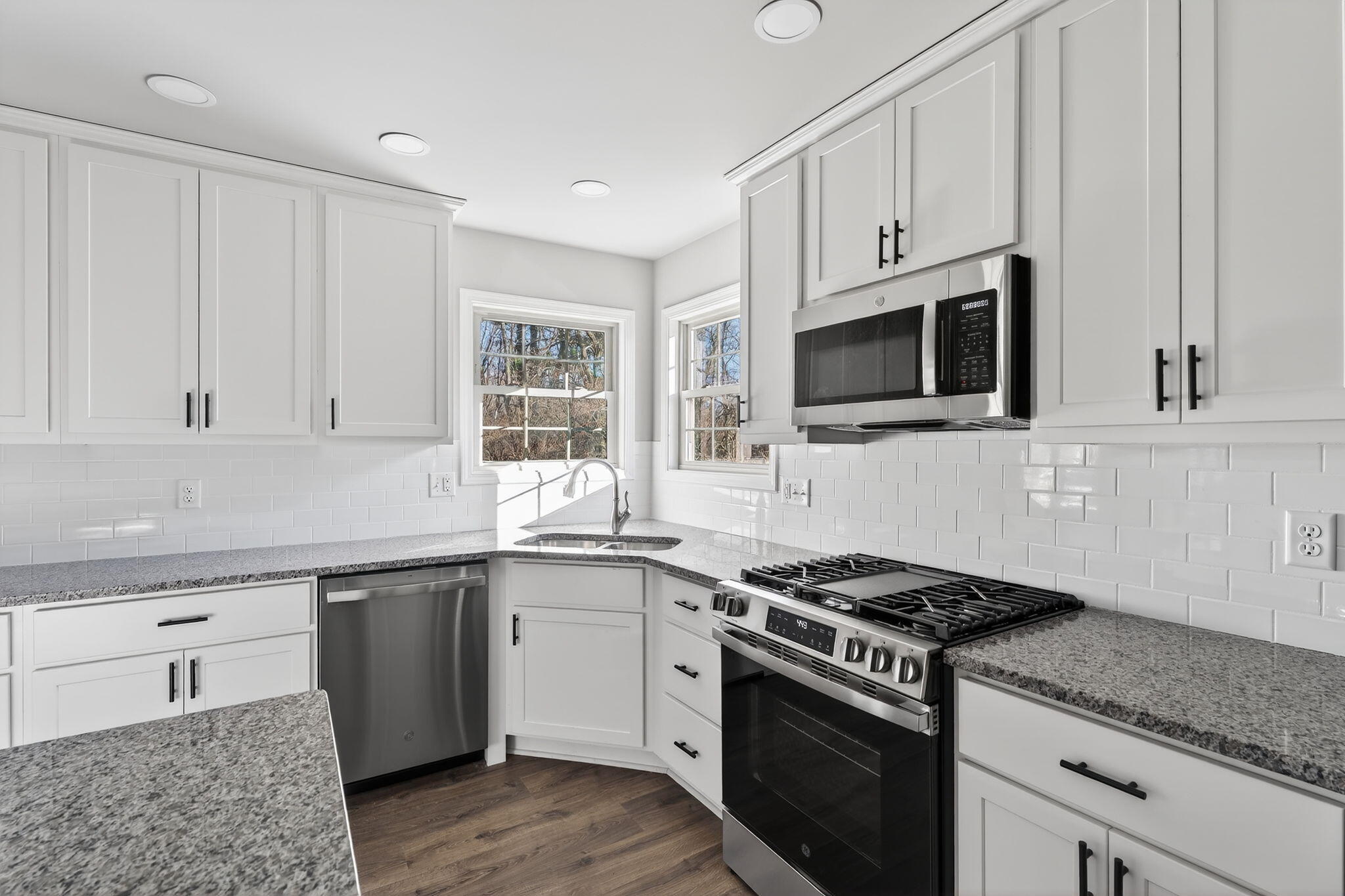 1611 Elderberry Street Southeast De Motte, IN 46310 - Photo 17 of 31 a kitchen with granite countertop cabinets stainless steel appliances and wooden floor