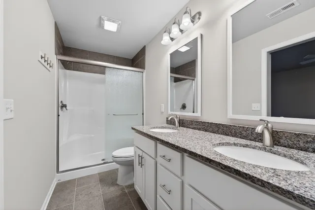 a bathroom with a granite countertop sink toilet and shower
