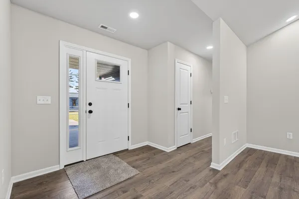 an empty room with wooden floor & wooden door
