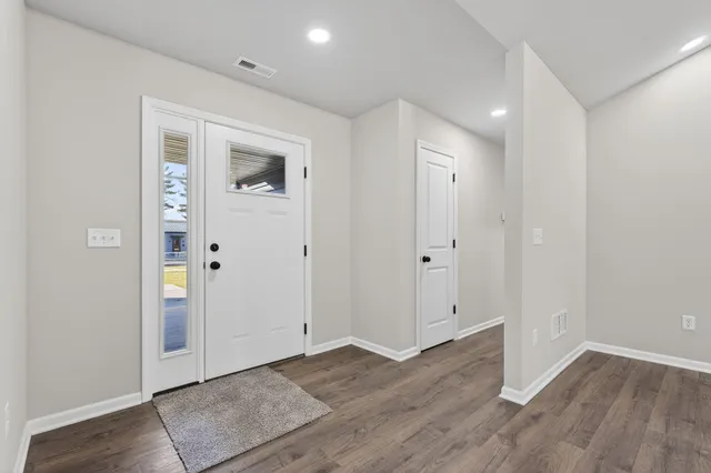 an empty room with wooden floor & wooden door
