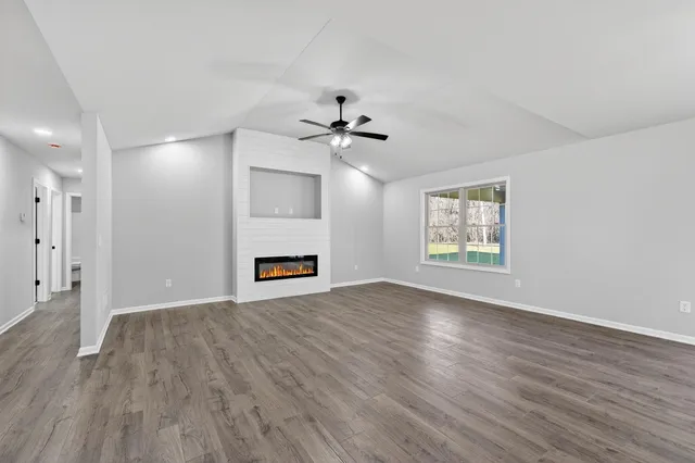 a view of an empty room with a fireplace and a window