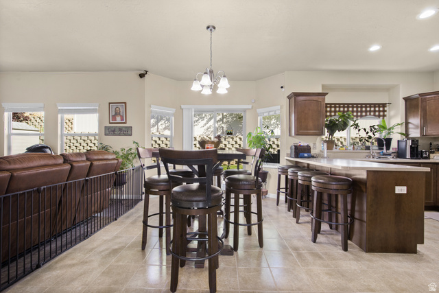 2005 Redtail Way Layton, UT 84040 - Photo 10 of 37 Open-concept living area featuring a kitchen island with seating, a separate dining area, recessed lighting, and tile flooring