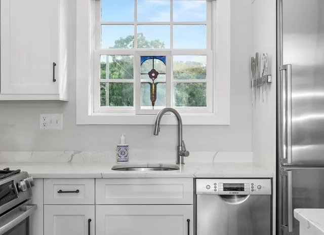 a kitchen with stainless steel appliances granite countertop a sink and a window
